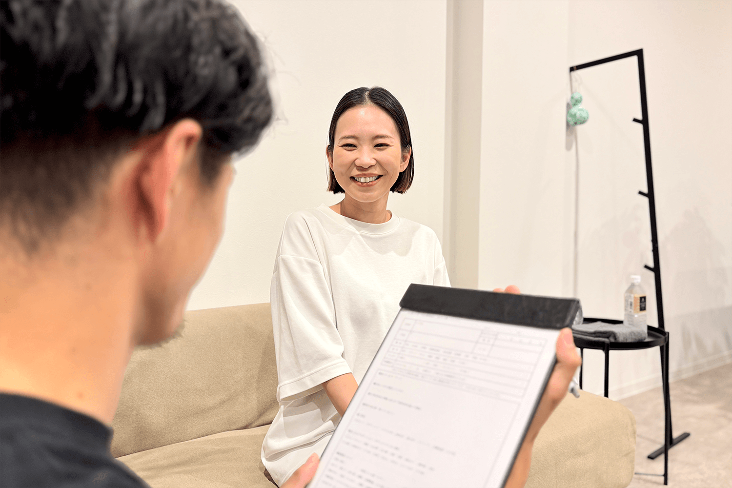 女性がのバスのトレーナーにカウンセリングの説明を受けている画像